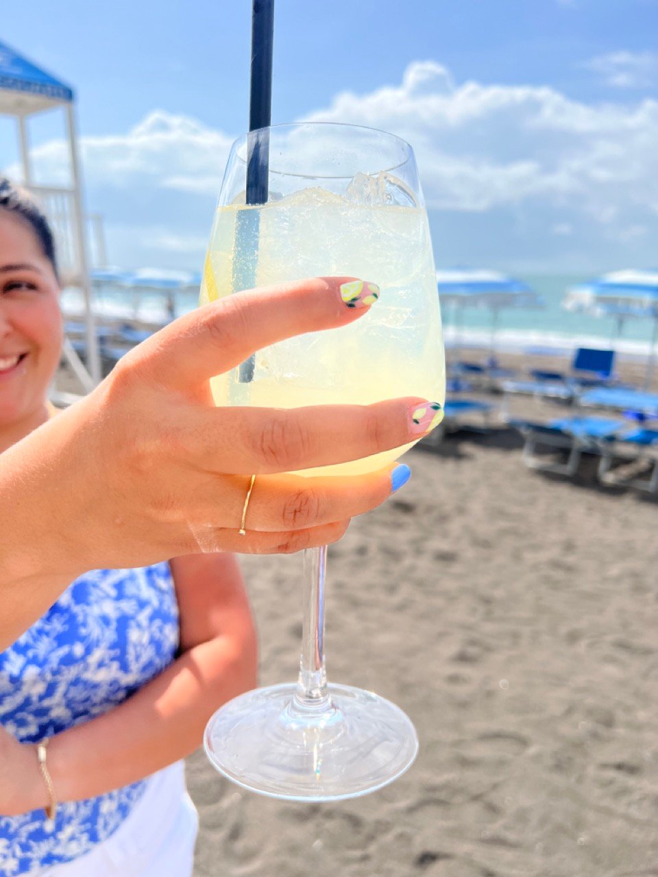 Traveler holding Limoncello spritz on the beach on the Amalfi Coast in Southern Italy.