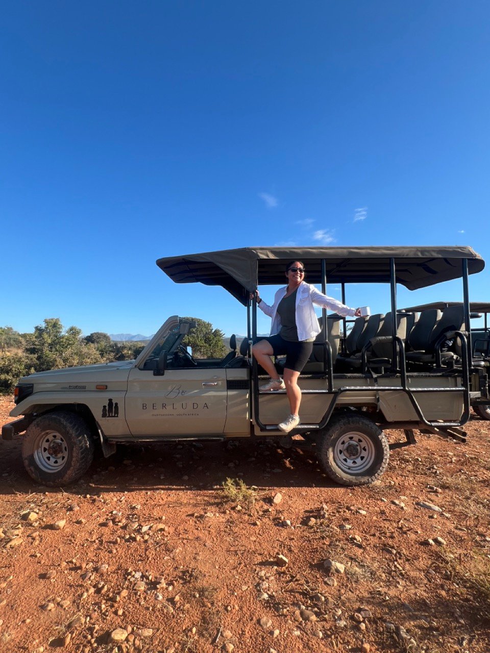 Woman standing on safari vehicle in South Africa.