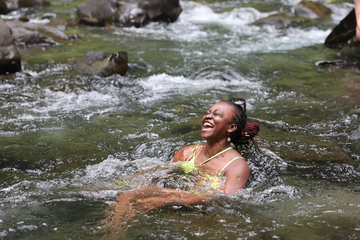 Woman swimming in river in Costa Rican jungle.